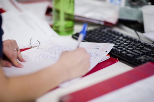 A nurse writing in patient notes