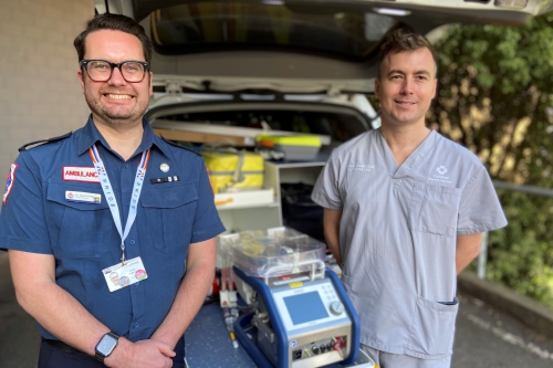 Trial leads pose with an ECMO machine.